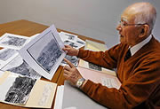Yoshitoshi Fukahori examina fotos del bombardeo nuclear de Nagasaki (© Noriko Tokuno / Mainichi Shimbun)