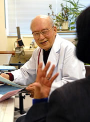 El doctor Shuntarō Hida ve a un sobreviviente de la bomba atómica. (Takeshi Nishimura / © Mainichi Shimbun)