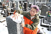 Kimie Kishi pule una lápida (Takeshi Nishimura / © Mainichi Shimbun)